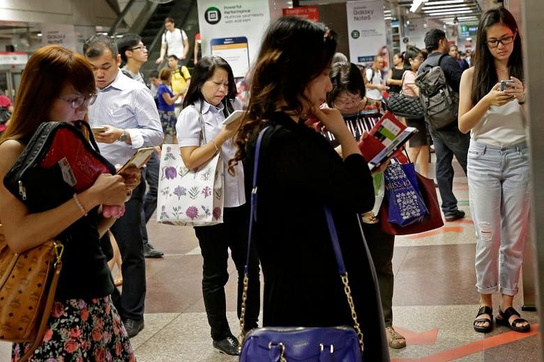 Commuters at City Hall MRT station. A mobile airwave auction will take place in the third quarter and the fourth telco could be rolling out its services as early as April next year.