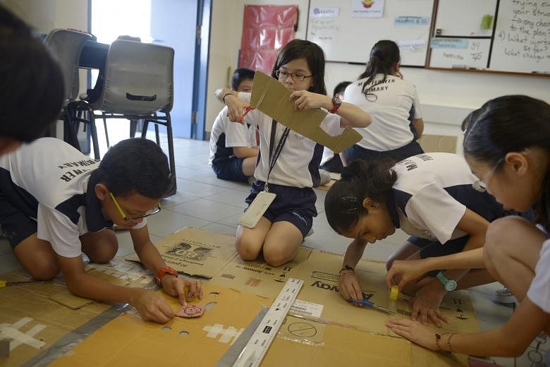 Mayflower Primary pupil Annabel Gan (centre), 12, cutting a piece of cardboard as classmates work on other parts of a prop. The project to design props for a skit teaches the children how to apply properties of a circle to a real-world context.