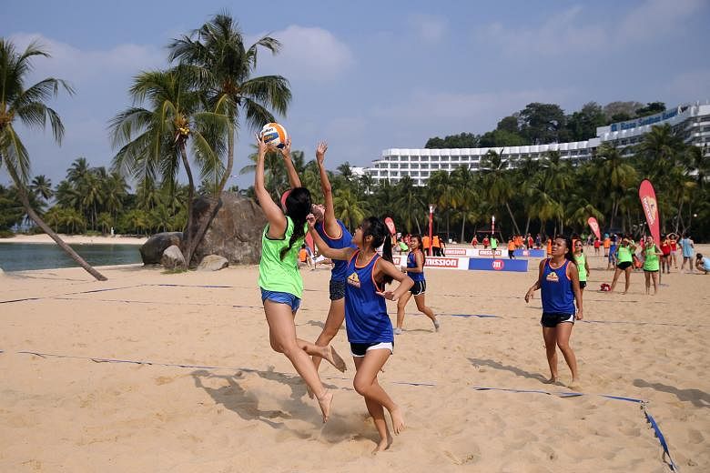 Netballers getting their kicks during the Mission Foods Beach Netball Festival at Siloso Beach on Sentosa yesterday. The event had its biggest turnout in seven years with 63 teams in five categories. Four-a-side games were played on a half court. In 