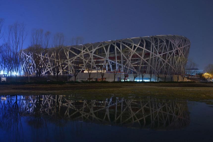 China's National Stadium, also known as the Bird's Nest, with its lights on (top) and off (above) during the annual Earth Hour event in the capital on Saturday. Millions of people around the world were expected to switch off their lights for Earth Ho