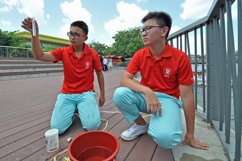 Pei Hwa Secondary students Idzhar Dandiar Bahtiar and Chee Kang Jie, both 15, testing a water sample from Punggol Reservoir for acidity and turbidity.