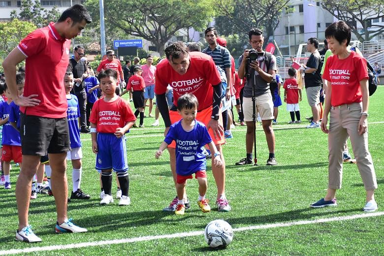 Former national goalkeeper Lionel Lewis (left), ActiveSG Football Academy principal Aleksandar Duric and Minister Grace Fu encouraging some of the 350 children who attended the launch of the programme yesterday.