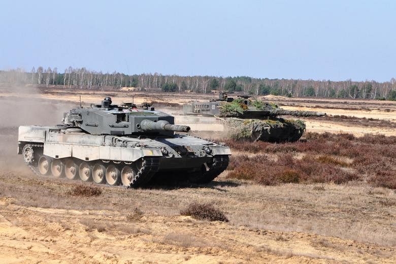 The Singapore Armed Forces' (SAF) Leopard 2SG main battle tank (foreground) and the German armed forces' Leopard 2A6 main battle tank participating in a live-firing drill in the Oberlausitz military training area in eastern Germany on Wednesday. More