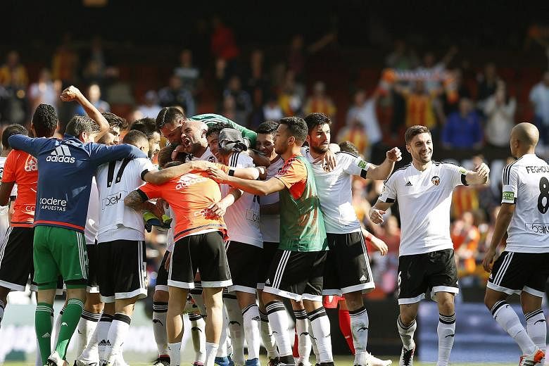 Valencia's players celebrate their dramatic 2-1 win under new coach Pako Ayestaran against Sevilla on Sunday. They are nine points clear of the relegation zone and will face Barcelona next.
