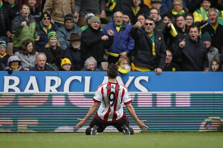 Sunderland striker Fabio Borini celebrates in front of the Norwich fans after scoring his side's opening goal from the penalty spot. The win allowed the Black Cats to go within one point of Norwich, with one game in hand.