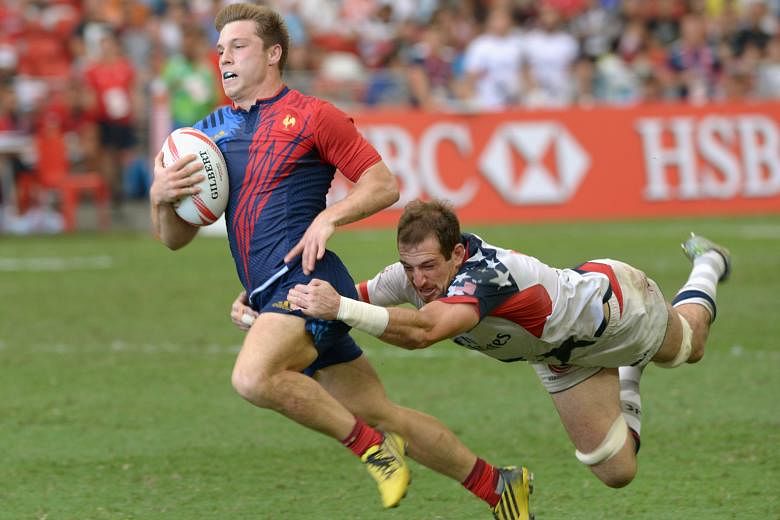 France's Stephen Parez (left) breaks away from the United States' Zack Test to score a vital try in their Singapore Rugby Sevens match at the National Stadium yesterday. France won the encounter 19-17.