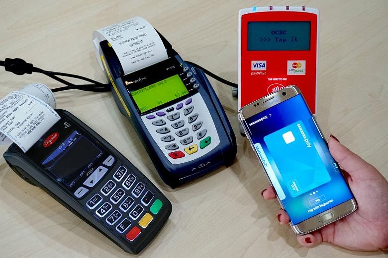 A Samsung Galaxy S7 edge being demonstrated with new near-field communication payment terminals (right and centre) and a traditional magnetic-stripe terminal (left). Samsung Pay works with both types of terminals.