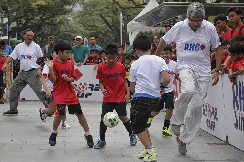 Minister for Communications and Information Dr Yaacob Ibrahim (right) and Football Association of Singapore president Zainudin Nordin (left) joined participants for a five-a-side kickabout as part of a curtain-raiser to the RHB Singapore Cup Kids' To