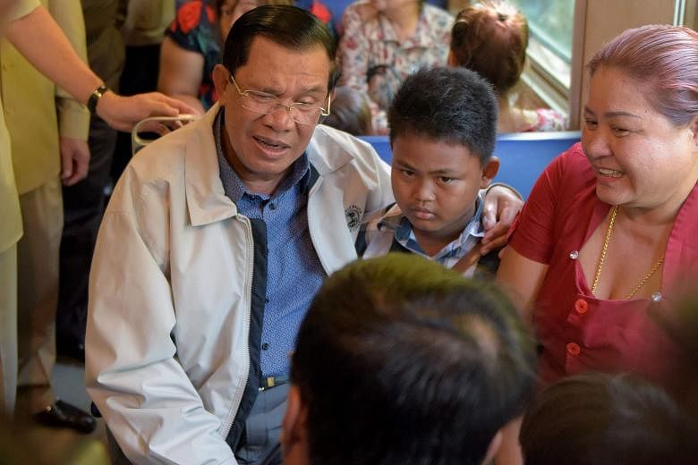 Cambodian Prime Minister Hun Sen with passengers at the Phnom Penh railway station yesterday, as the country's sole passenger train service resumed after a 14-year hiatus. Mr Hun Sen boarded the train to inaugurate its first trip to a seaport in Siha