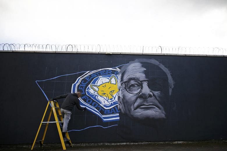 Artist Richard Wilson spray paints a mural of Leicester City manager Claudio Ranieri and the Foxes' club crest in Leicester. The city are preparing for celebrations should their team create English football history today.