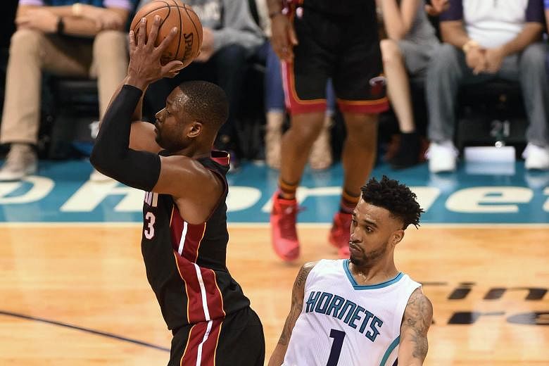 Miami Heat guard Dwyane Wade shrugs off the attentions of Charlotte Hornets guard Courtney Lee to shoot during the second half in Game 6 at the Time Warner Cable Arena. The Heat won 97-90 to take the series to a Game 7 decider in Miami.