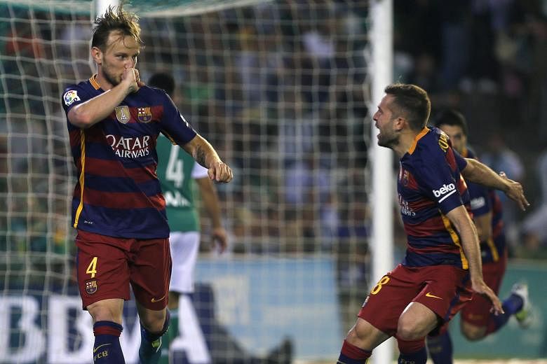 Barcelona's Ivan Rakitic (left) celebrates with Jordi Alba after scoring the opening goal against Real Betis five minutes into the second half. Barca won 2-0 to stay at the top of the La Liga table on 85 points.