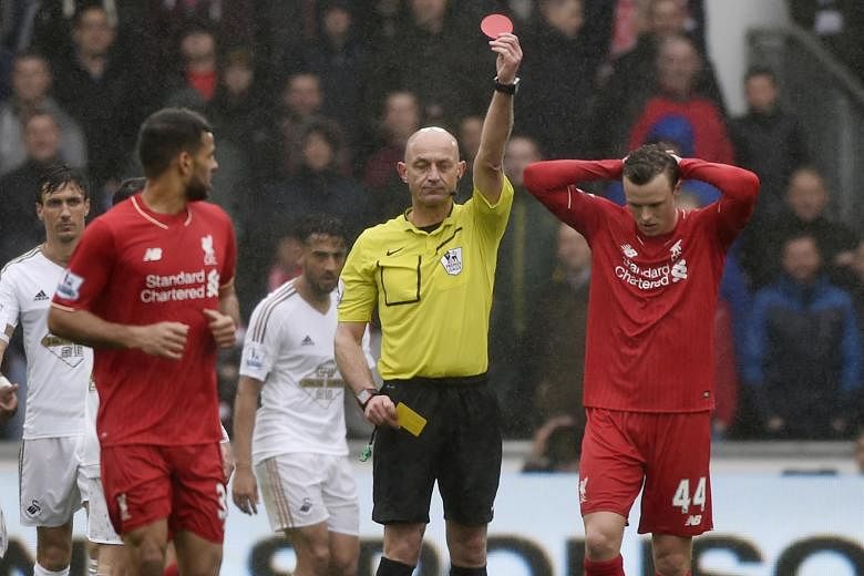 Liverpool defender Brad Smith (right) holds his head in his hands as referee Roger East shows him a second yellow card in the 76th minute. Smith was among eight changes Reds boss Juergen Klopp made to the side that lost to Villarreal in the Europa Le