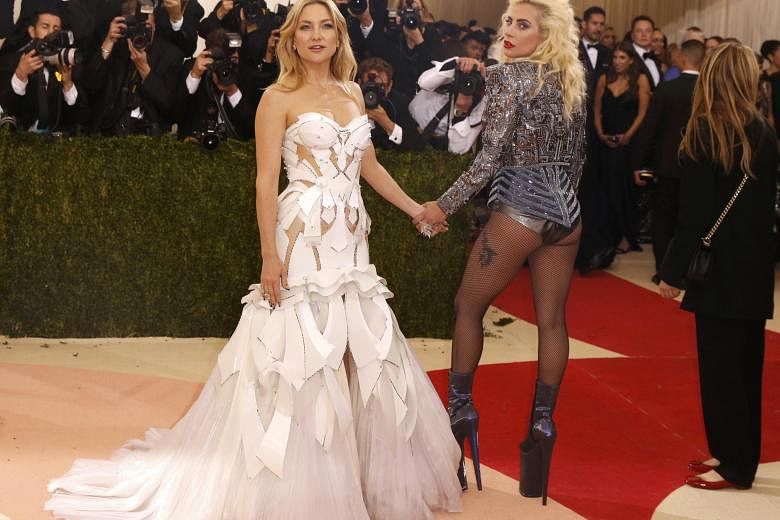 Kate Hudson (far left) and Lady Gaga are two of the night’s most superbly dressed celebrities. Gaga honours 1980s “hair metal” with her teased hair and beaded bolero jacket, while Hudson’s fantastic plastic gown pays tribute to sci-fi. 