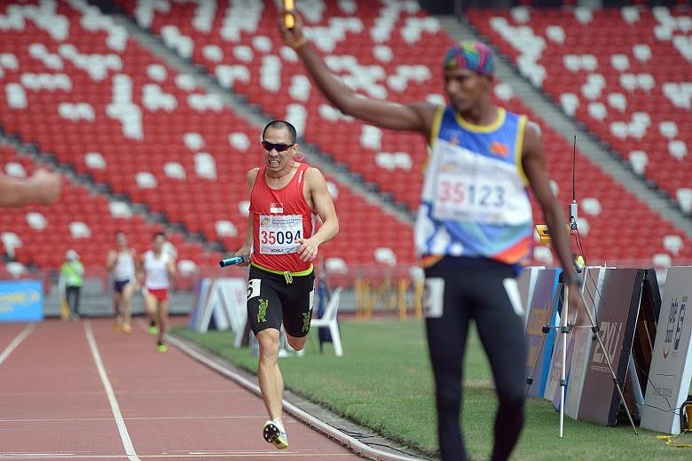 Lien Choong Luen, in red, brings Singapore a silver medal in the 4x400m relay for men over 35 in the final event of the Asia Masters Athletics Championships yesterday.