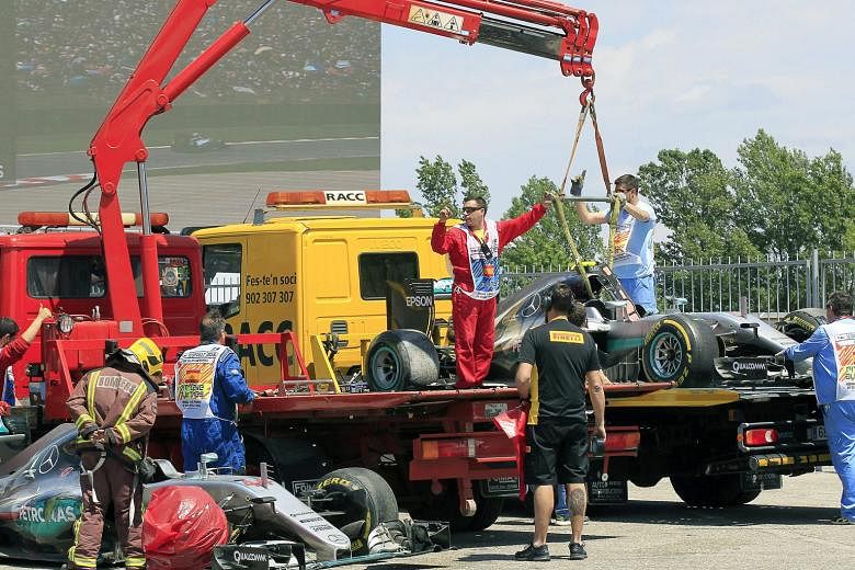 A horrible day at the office for the Mercedes drivers, as the cars of Formula One triple champion Lewis Hamilton (left) and team-mate Nico Rosberg are towed away after they crashed in the Spanish Grand Prix. Hamilton is the bigger loser as he drops t