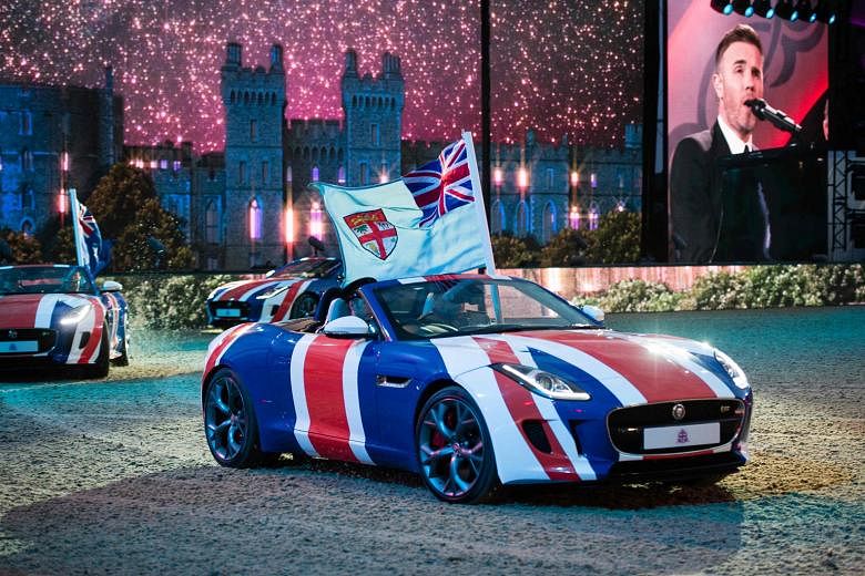 British singer Gary Barlow crooning away while Jaguar sports cars are driven around the arena during the final night of the 90th birthday celebrations for Queen Elizabeth II at the Royal Windsor Horseshow. 	The event, held on the grounds of Windsor C