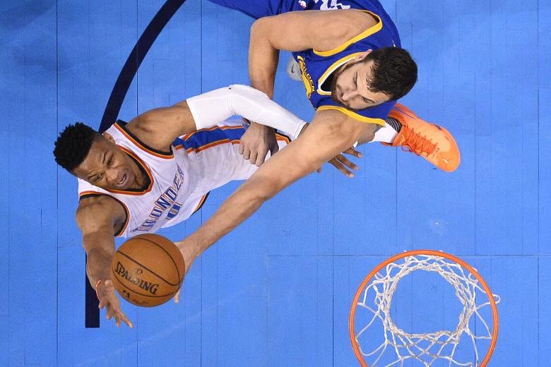 Andrew Bogut (right) of the Golden State Warriors tries to block a shot by Russell Westbrook during the 105-133 loss to Oklahoma City Thunder in Game 3 of the Western Conference Finals on Sunday.