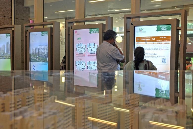 Sales assistant Mr Joseph and his wife consulting the digital display of the 3,770 BTO flats and 5,170 balance flats on offer at Toa Payoh HDB Hub.