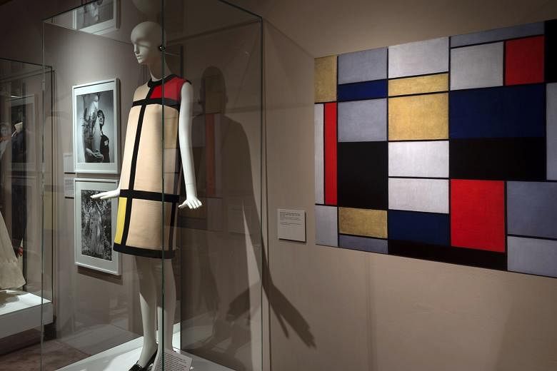 A cocktail dress (above) by Yves Saint Laurent, inspired by an oil painting by Dutch painter Piet Mondrian, and a wooden dress (right) by Japanese designer Yohji Yamamoto at the Across Art And Fashion exhibition. Shoes by Italian designer Salvatore F