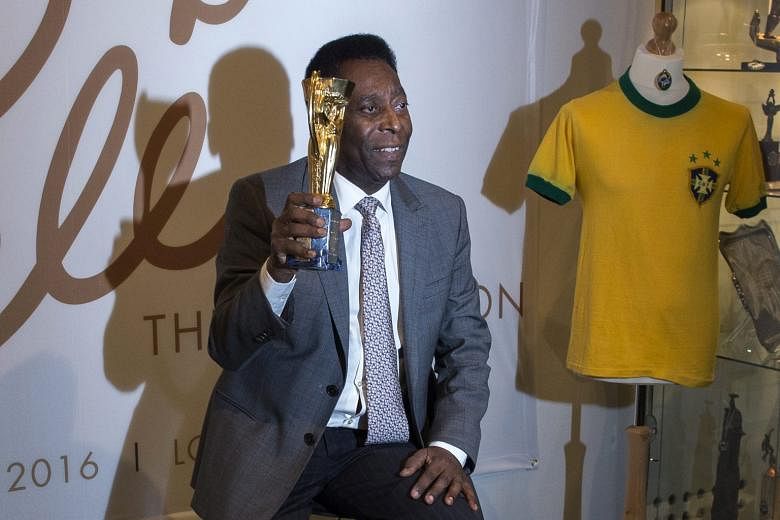 Pele holding a replica of the Jules Rimet Trophy during a preview last week of the US auction of his belongings.