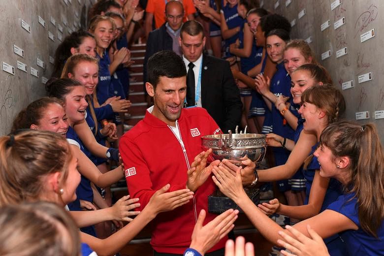 Novak Djokovic celebrating his French Open win with ball girls. The world No. 1 has set his sights on becoming only the third man to capture a calendar-year Grand Slam.