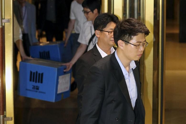 South Korean investigators carrying out confiscated documents from the HQ of Lotte Group in Seoul on Friday.