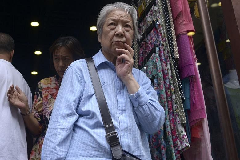 A couple in their 70s inside their shipping-container home in Brazil and (below) an elderly woman out shopping in Beijing. People are living longer and more money has to go into savings.