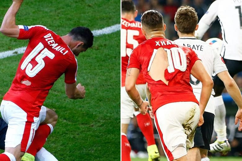 Blerim Dzemaili(far left) and Granit Xhaka's shirts were among those torn during the game against France. The Swiss will be hoping for their kit manager to be better prepared when they play in the last 16.