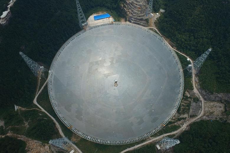 China's 500m aperture spherical telescope, named Fast, pictured at three different assembly stages in Pingtang County, south-west Guizhou province. The topmost photo was taken in August last year, the second in December, and the third on Wednesday. F