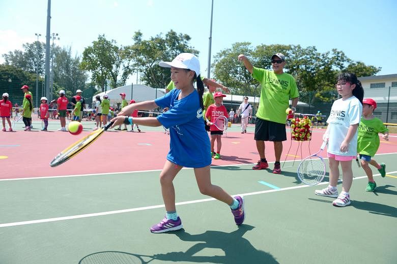Eight-year-old Koh Wensyn learning to play mini tennis at yesterday's launch of the ActiveSG tennis academy at the Kallang Tennis Centre. The academy is the fourth introduced under the national movement for sport.