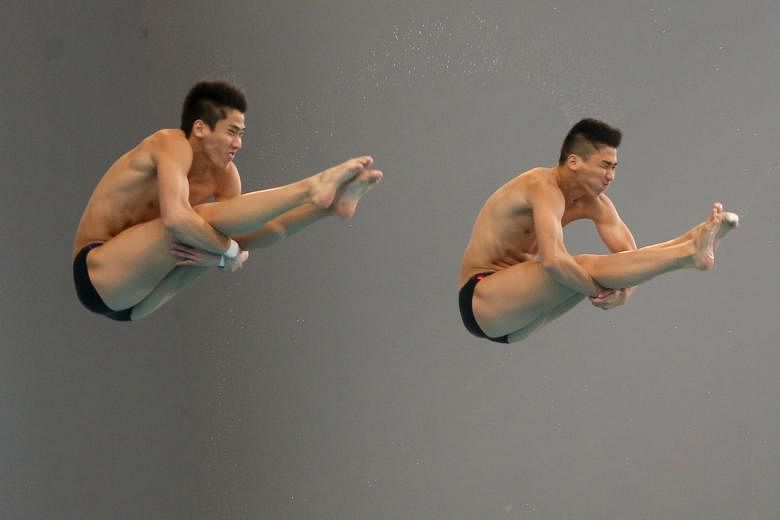 Twins Mark (left) and Timothy Lee on their way to winning gold in the Fina open men's 3m synchronised category yesterday at the National Diving Championships at the OCBC Aquatic Centre.