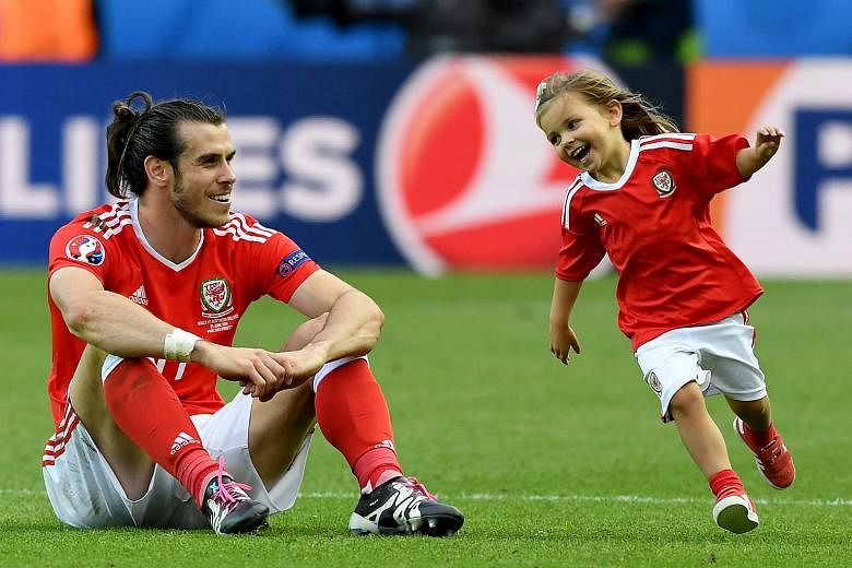 Gareth Bale of Wales enjoying his time with his daughter after the 1-0 round-of-16 victory over Northern Ireland on June 26.