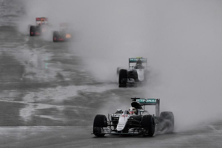 Amid the spray and grey conditions in the early stages of the British Grand Prix on Sunday, Lewis Hamilton leads his Mercedes team-mate Nico Rosberg. Hamilton won the race, his third straight victory in his home GP and his fourth British title in tot