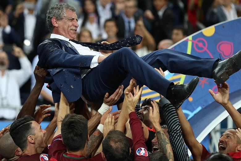 Portugal's coach Fernando Santos is tossed into the air by his players as they celebrate after beating France in the Euro final.