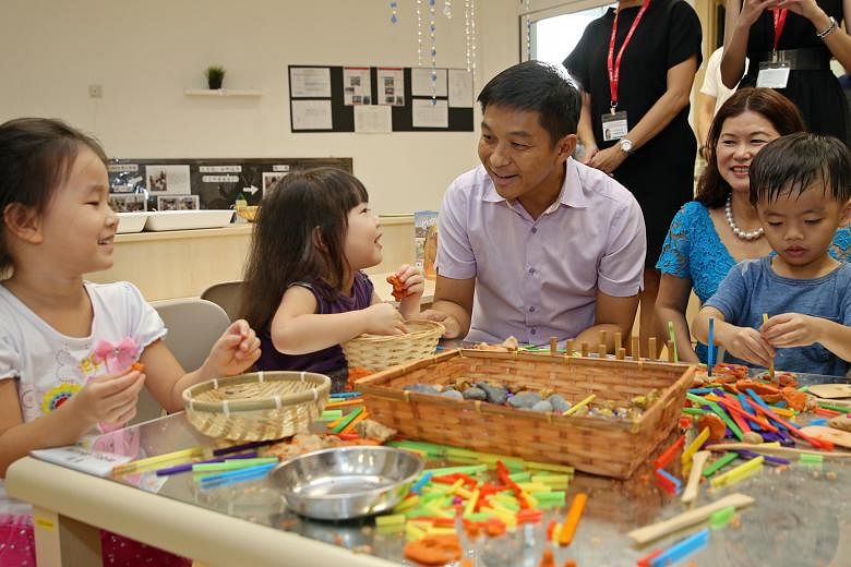 Minister for Social and Family Development Tan Chuan-Jin at the new E-Bridge Pre-School yesterday. With him are pre-schoolers (from left) Wang Yunhan, four; Tan Le En Eryn, three; and Jovan Pang; three.