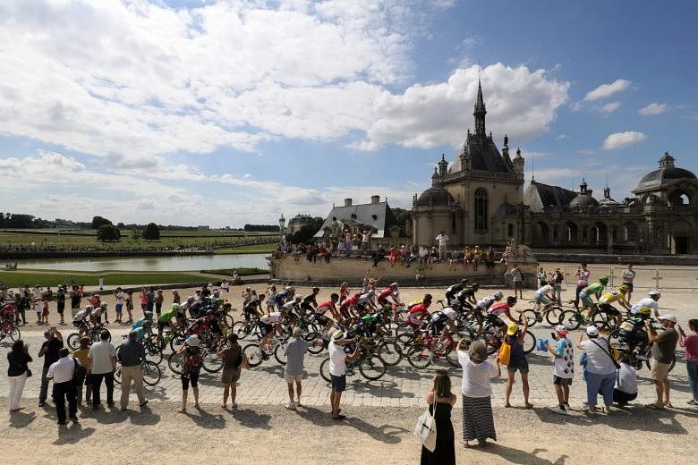 The pack riding past Chantilly Castle at the start of the 113km 21st and last stage of the 103rd Tour de France. Despite the tight security, one of the charms of the race is the ability of fans to get up close to their sporting heroes.