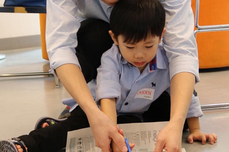 Mr Lee Thiam Yew, 36, and his son Cayden Lee, four, working at transforming a news story from Little Red Dot into their own front-page news during an ST Schools workshop last Saturday.