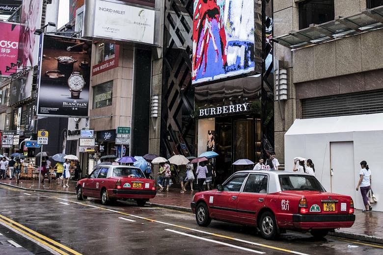 Landlords on Hong Kong's Russell Street (left) in the prime Causeway Bay shopping district are adjusting to lower retail rents.