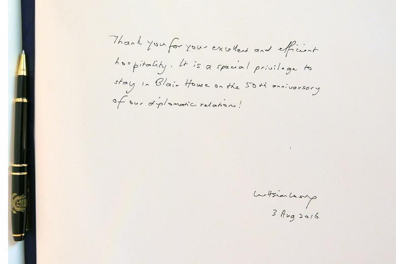 Left: PM Lee leaving this message (above) in the guest book at Blair House, the guest house of the US President. With him were Mrs Lee and Mr Randell Bumgardner, Blair House assistant chief of protocol and general manager.