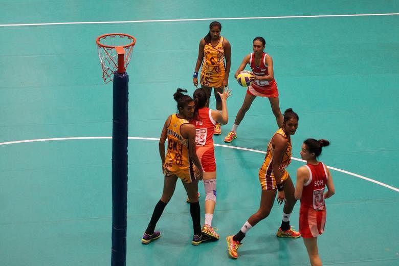 Singapore vice-captain Nurul Baizura (in red) trying to pass the ball to team-mate Yu Meiling during the semi-final of the Asian Netball Championships yesterday. The Republic lost 30-36 to Sri Lanka.