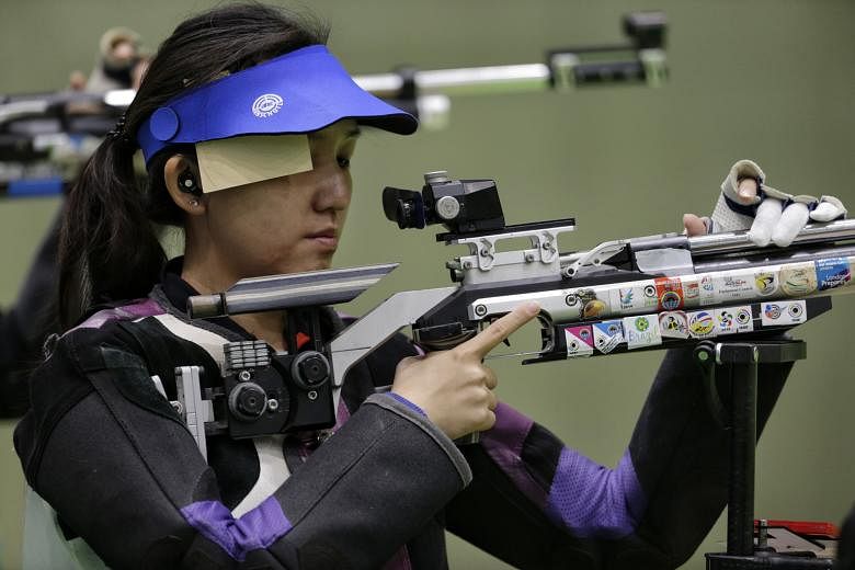 Jasmine Ser preparing to shoot during the women's 10m air rifle event yesterday. She finished 25th out of 51 competitors with a score of 413.5, but said, "I'm OK" while shifting her focus to the 50m three-position event.