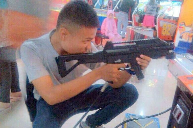 Mr Tegar, seen here playing an arcade game, was among six suspected militants nabbed in Batam last Friday, but was released that evening after questioning. His friend Hadi remains in police custody.