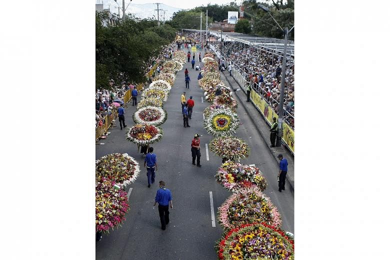 People carrying flower arrangements on their backs during the Festival of the Flowers in Medellin, Colombia, on Sunday. More than 24,000 visitors were expected to attend the annual festival - the city's biggest - during which people carry flowers on 