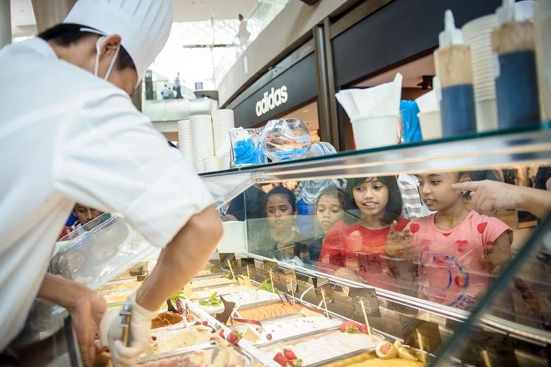 Straits Times School Pocket Money Fund beneficiaries selecting flavours at the Scoops of Hope booth. Earnings from 9,778 scoops of gelato sold at MBS went to the fund.