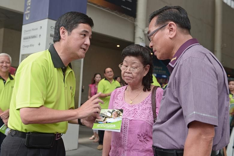 Mr Heng (left) explaining a new NTUC guidebook on re-employment to Madam Sng and Mr Lim Yew Huat, 65, an SBS chief bus captain. The re-employment age will be raised from 65 to 67 from July 1 next year.