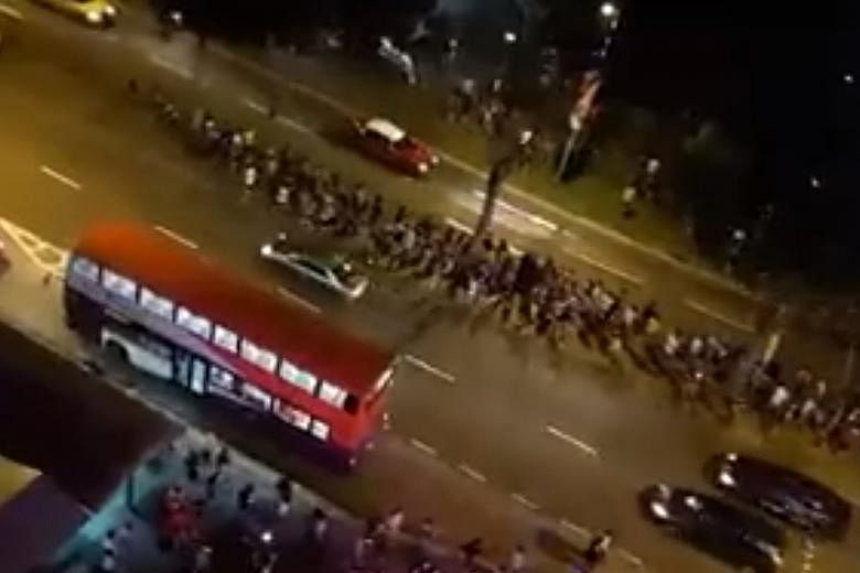 A screengrab from a video posted on Facebook showing a crowd of Pokemon Go players rushing to Punggol Park with no apparent heed to the traffic on the road.
