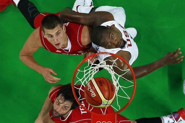 Serbia's Milos Teodosic (bottom) and Nikola Jokic jostling for space with the US' Kevin Durant during their Group A match at the Carioca Arena 1. The Americans edged out Serbia 94-91.