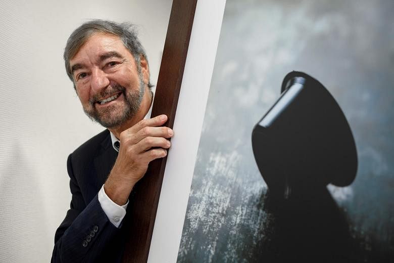 Nespresso inventor Eric Favre with a picture of a coffee capsule.