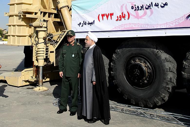 President Hassan Rouhani (right) and Defence Minister Hossein Dehghan standing next to the Bavar 373, Iran's new long-range missile defence system.